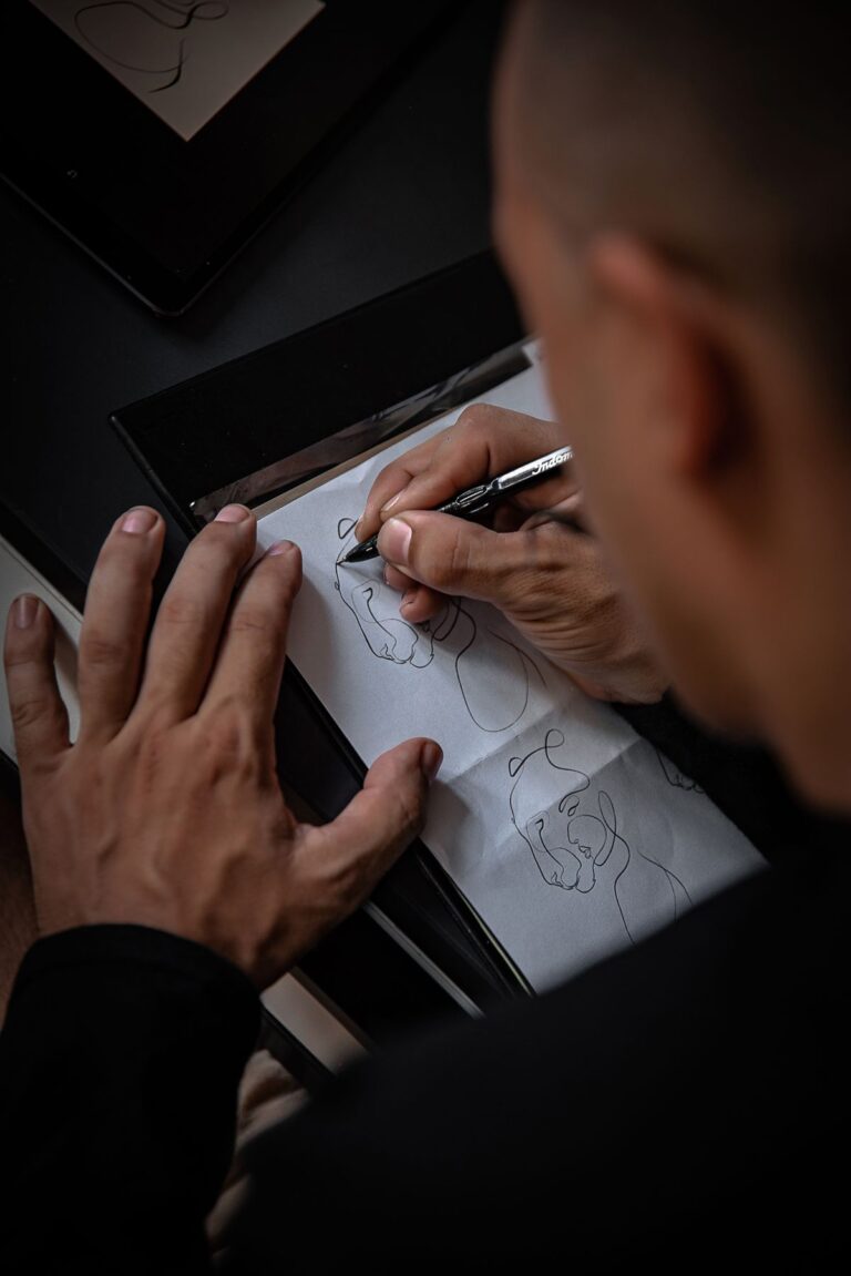 Tatuadora desenhando no papel um projeto para cobertura de tatuagem nas costas