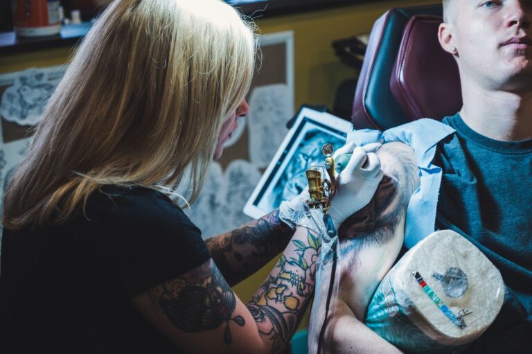 Tatuadora criando um desenho delicado no braço de uma cliente em estúdio