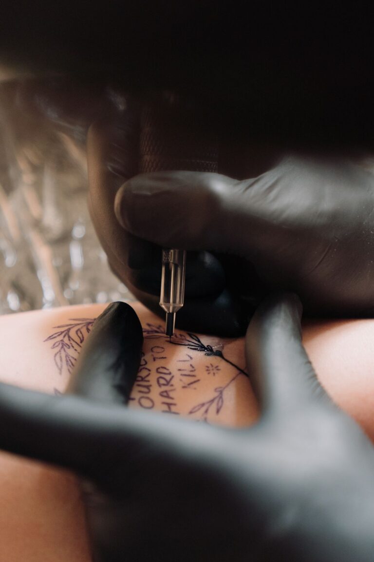 Tatuagem de traço fino feminina sendo feita no braço com agulha fina