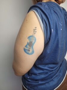 Tatuagem de violão no braço