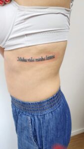 Tatuagem de frase na costela